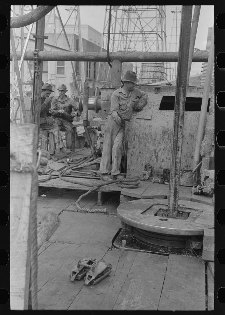 Oil drillers talking with drill bits in front of them, Kilgore, Texas — April 1939
